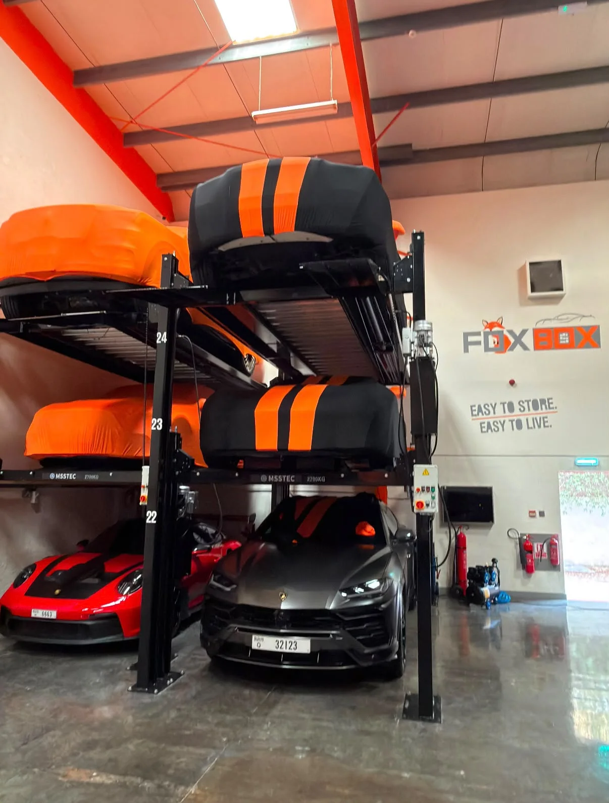 Car lift with a Porsche GT3 and a Macan